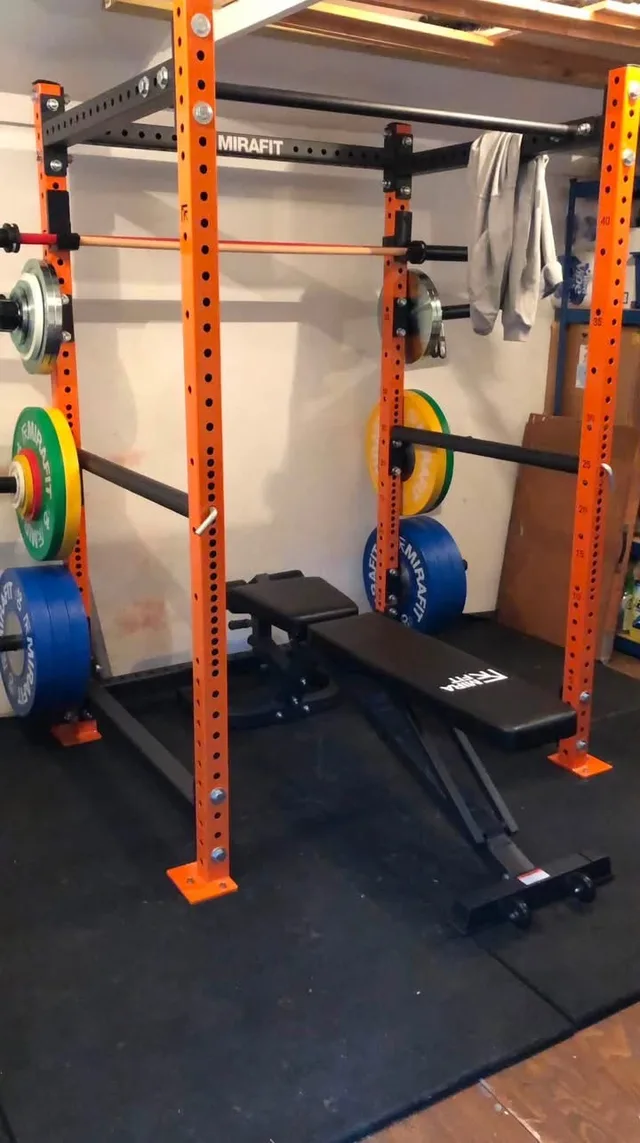Rob’s first garage gym with an orange Mirafit rack and weight bench