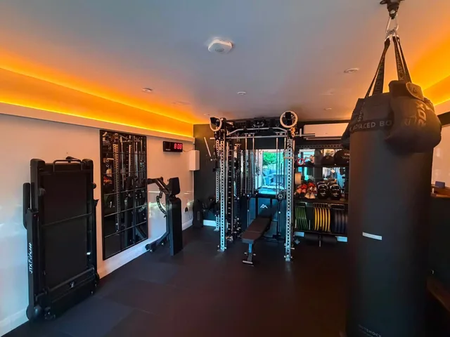 An open training area beside Rob’s rack, with a ceiling-mounted punchbag